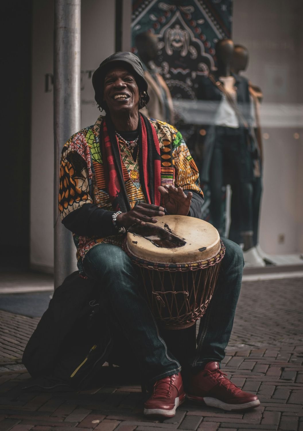 Drummer in a printed shirt playing a djembe