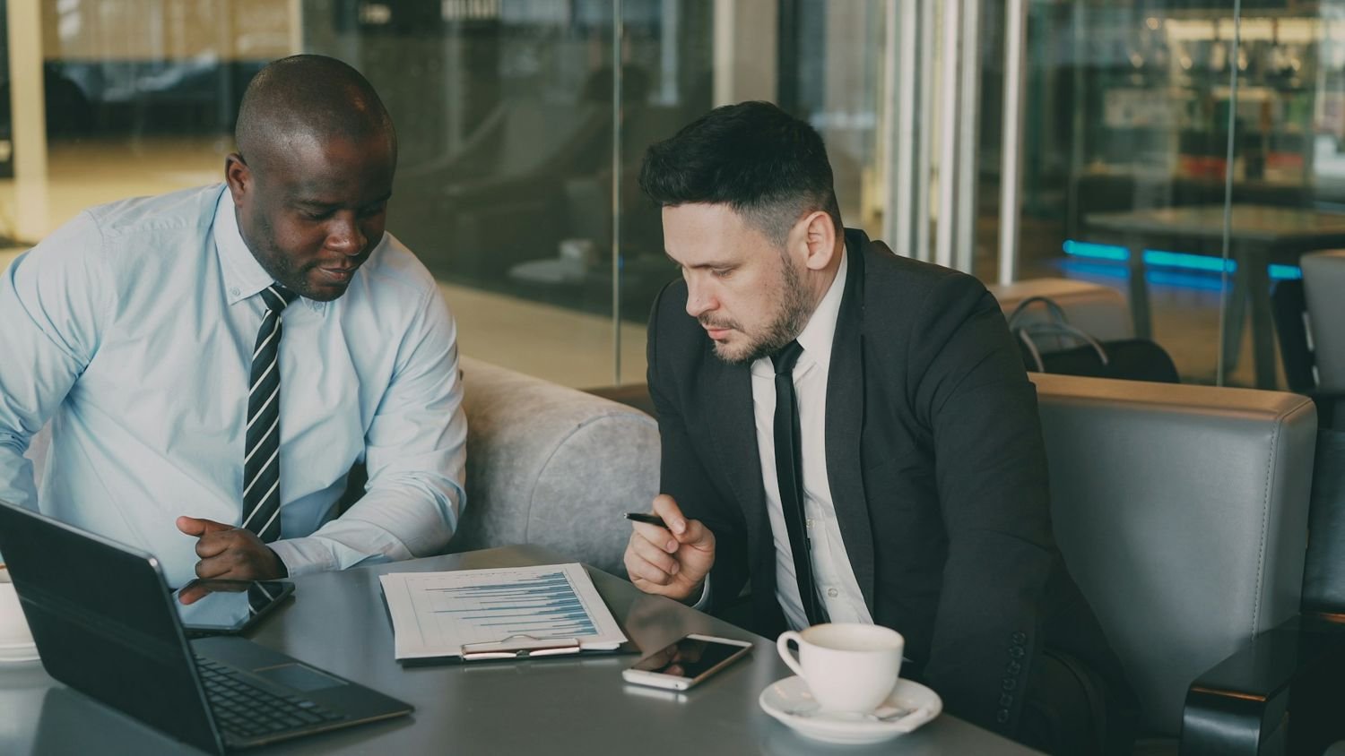 Two businessmen reviewing documents at a table