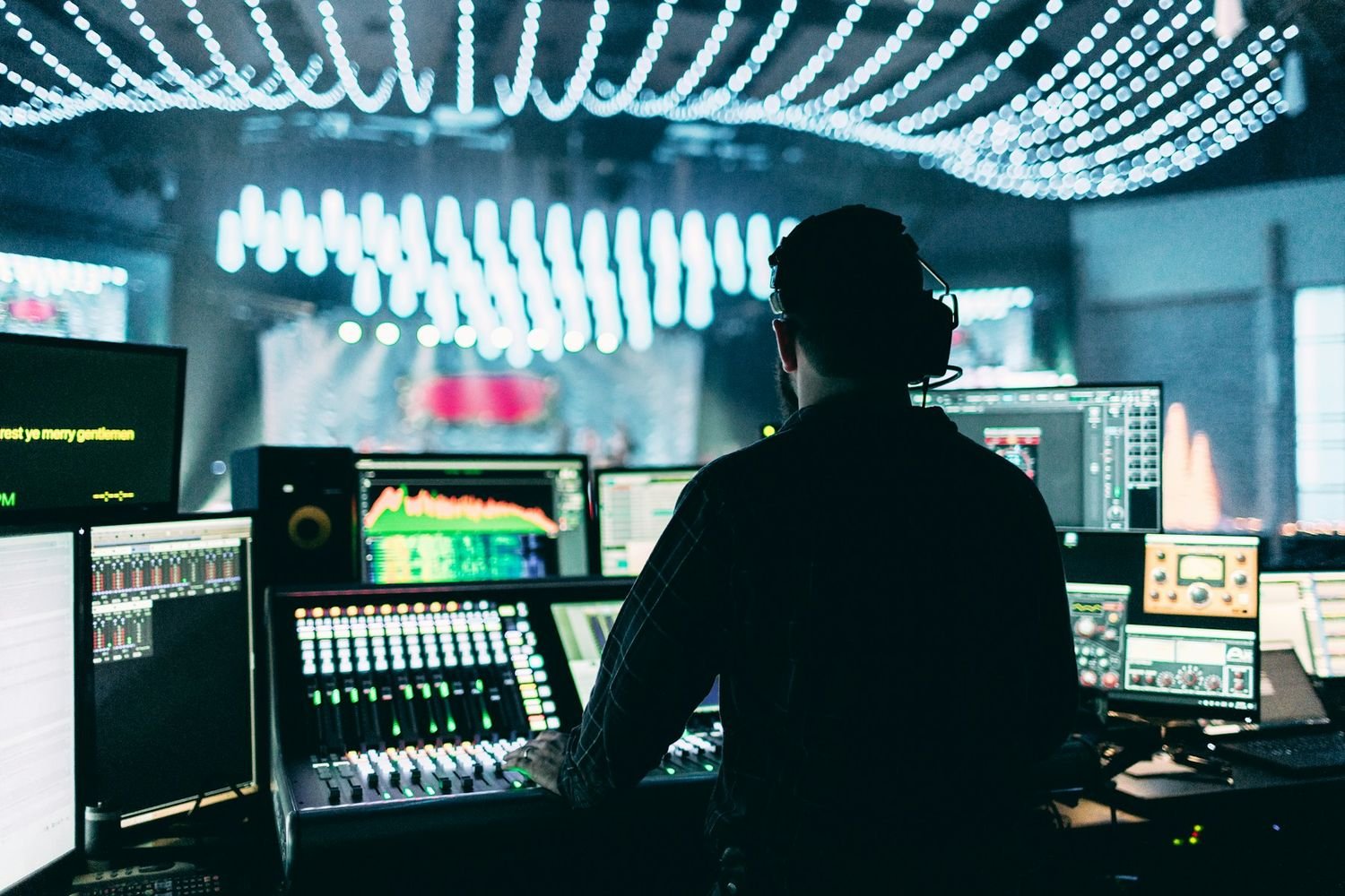 Production operator at a live control console under stage lights