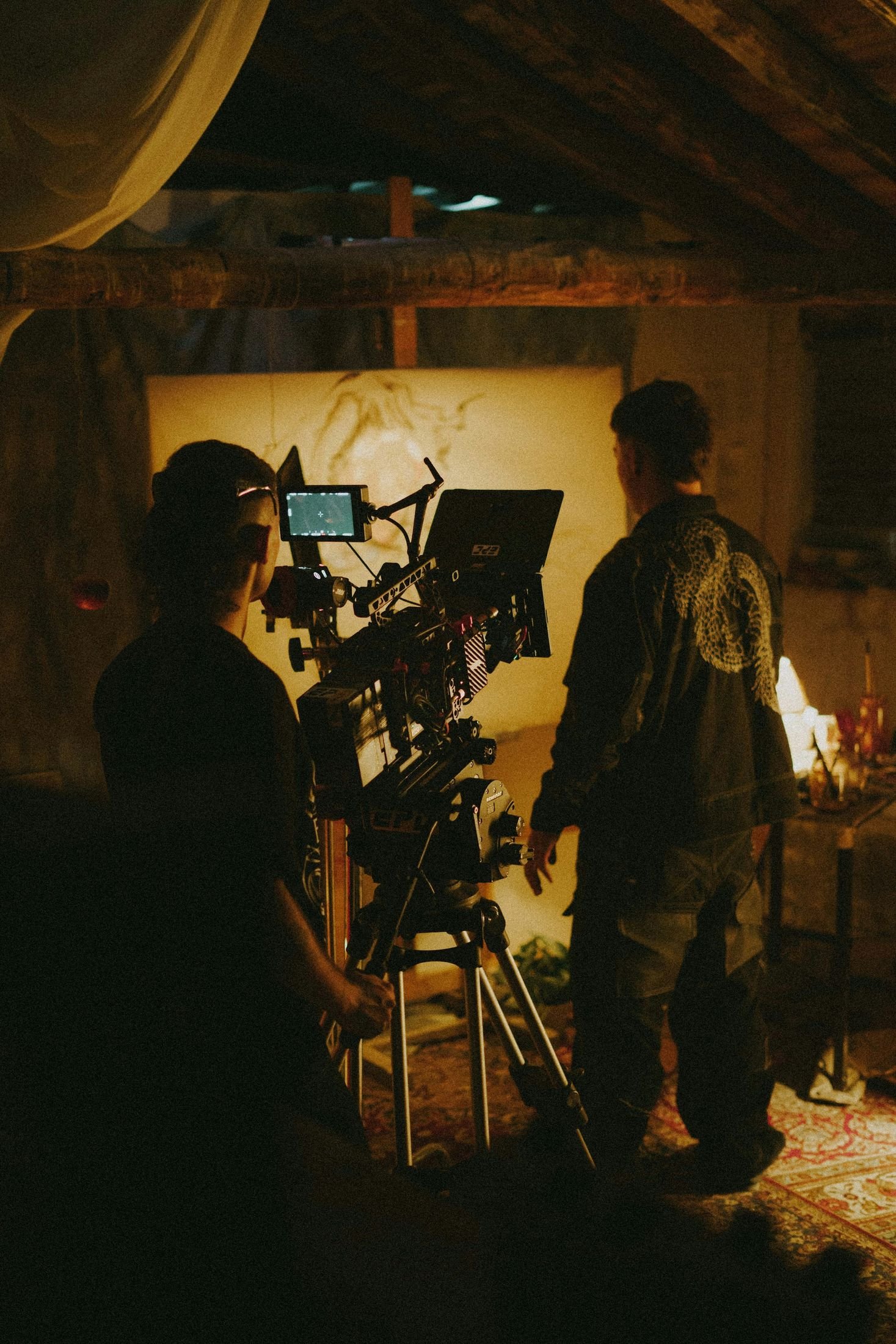 Film crew working a cinema camera on a dimly lit set